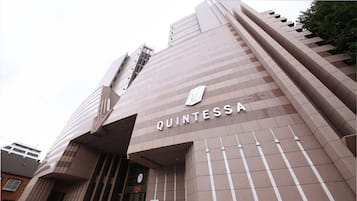 A building with a modern architectural design, featuring a prominent 'QUINTESSA' sign on the facade.