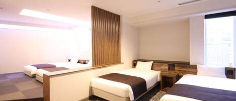 A hotel room with two beds, a wooden headboard, a large window, and a patterned carpet.