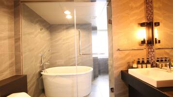 A modern bathroom with a glass-enclosed shower, a freestanding bathtub, and a vanity with a mirror and sink.
