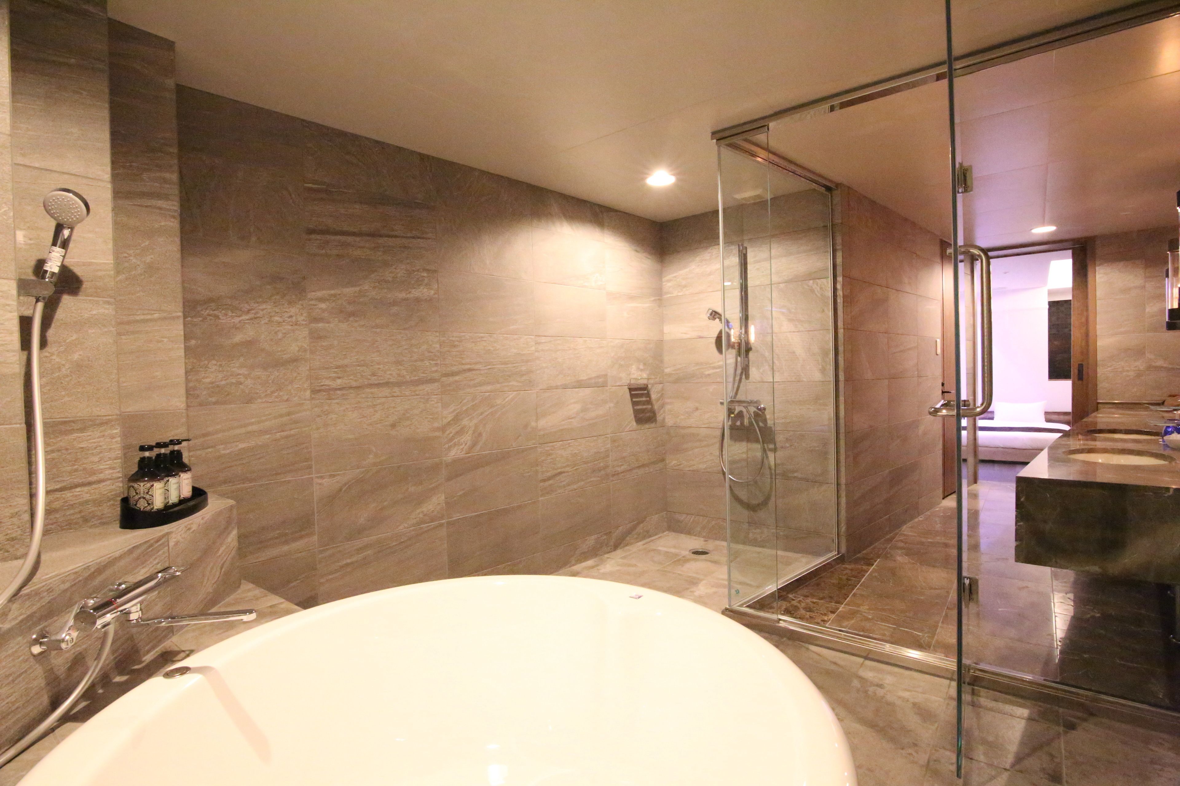 A modern bathroom with a glass-enclosed shower, a freestanding bathtub, and a vanity with a sink.