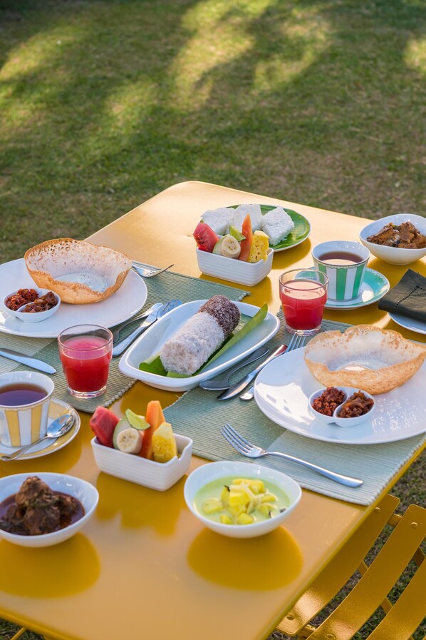 A table set with various dishes including a bowl of soup, a plate of rice, and a fruit bowl.