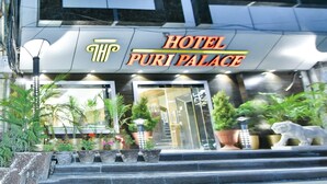 Un edificio de varios pisos con un cartel que dice 'HOTEL PURI PALACE'.
