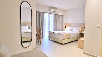 A modern hotel room with a large bed, a desk, and a chair.