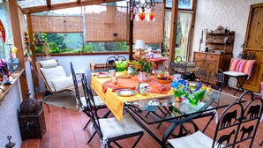 Un patio techado con una mesa de comedor para cuatro personas, rodeado de sillas.