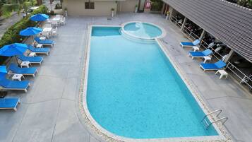 Een buitenzwembad en ligstoelen