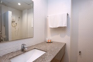 A bathroom with a white sink, a mirror, a towel rack, and a shower. - Pattra Mansion by AKSARA Collection (Phuket)