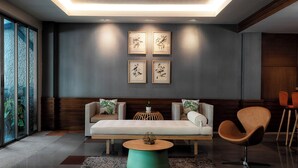 Een moderne woonkamer met een bank, fauteuils, een salontafel en kunstwerken in lijsten aan de muur.