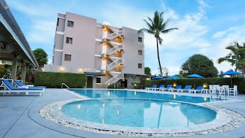 Een buitenzwembad en ligstoelen