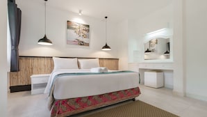 Habitación de hotel moderna con una cama bien hecha, una mesita de noche, un espejo y una lámpara colgante.