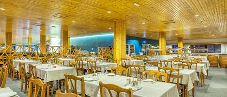 Ein großzügiges Restaurant mit Holzbalkendecke und gedeckten Tischen.