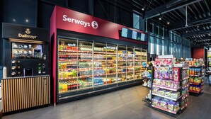 Una tienda de comestibles con una sección refrigerada y una máquina expendedora de bebidas.