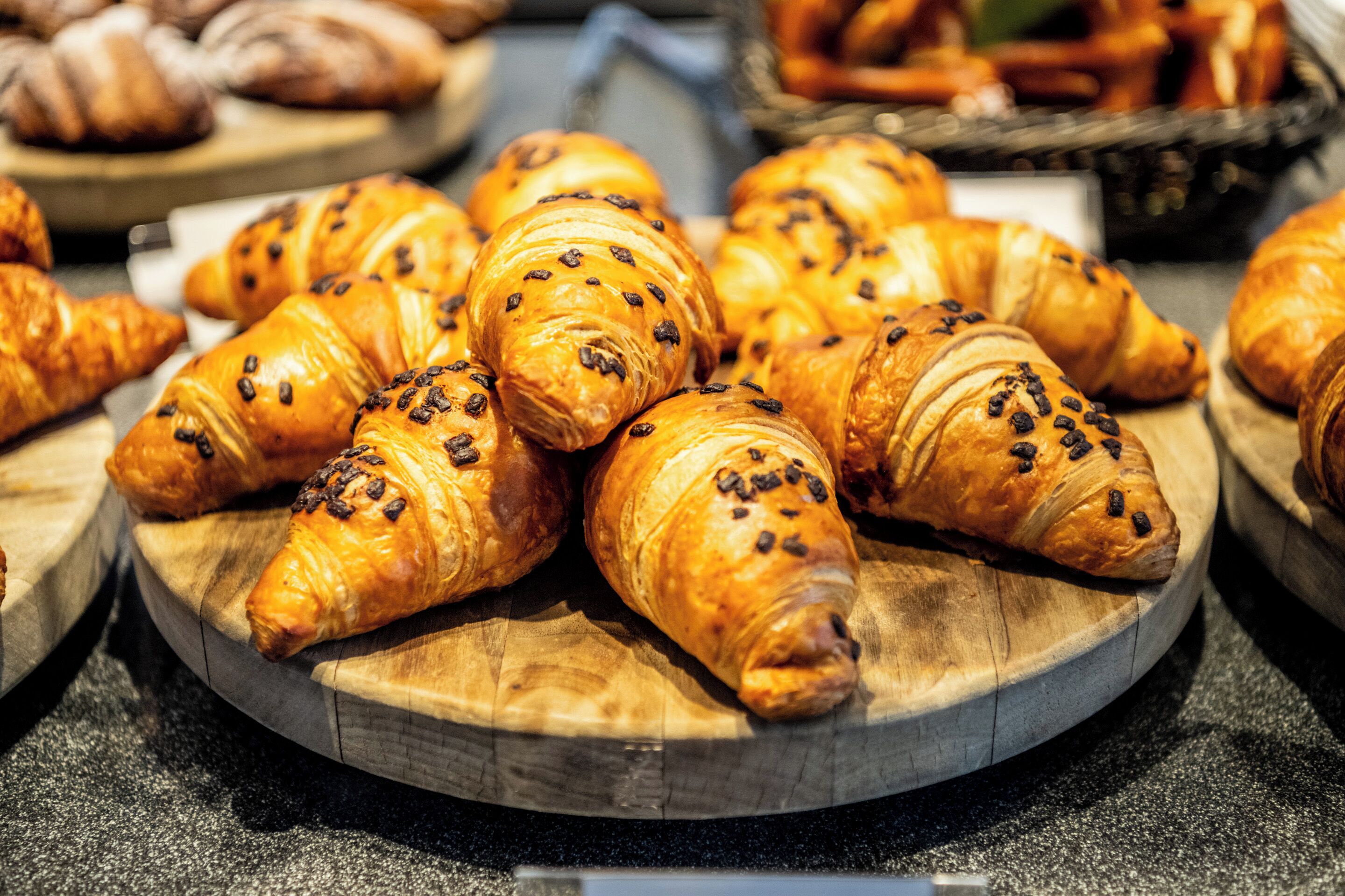 Une variété de croissants présentés sur des planches en bois.