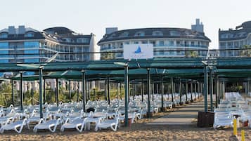 Privéstrand vlakbij, ligstoelen aan het strand, parasols