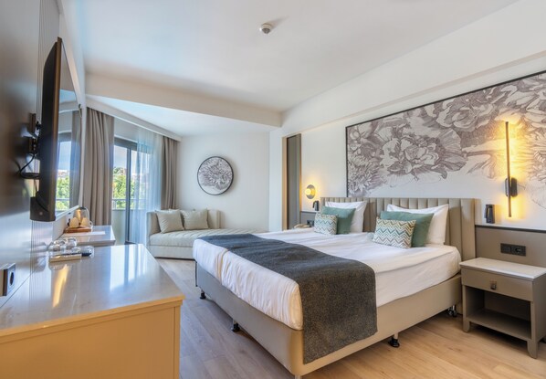 A modern hotel room with a bed, bedside tables, a desk, a television, and a large window with curtains. - Side Breeze Hotel - All Inclusive (Manavgat)