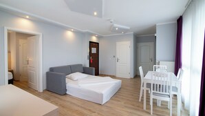 A modern bedroom with a bed, a desk, and a dining table. - Nautic Hotel Bremerhaven (Bremerhaven)