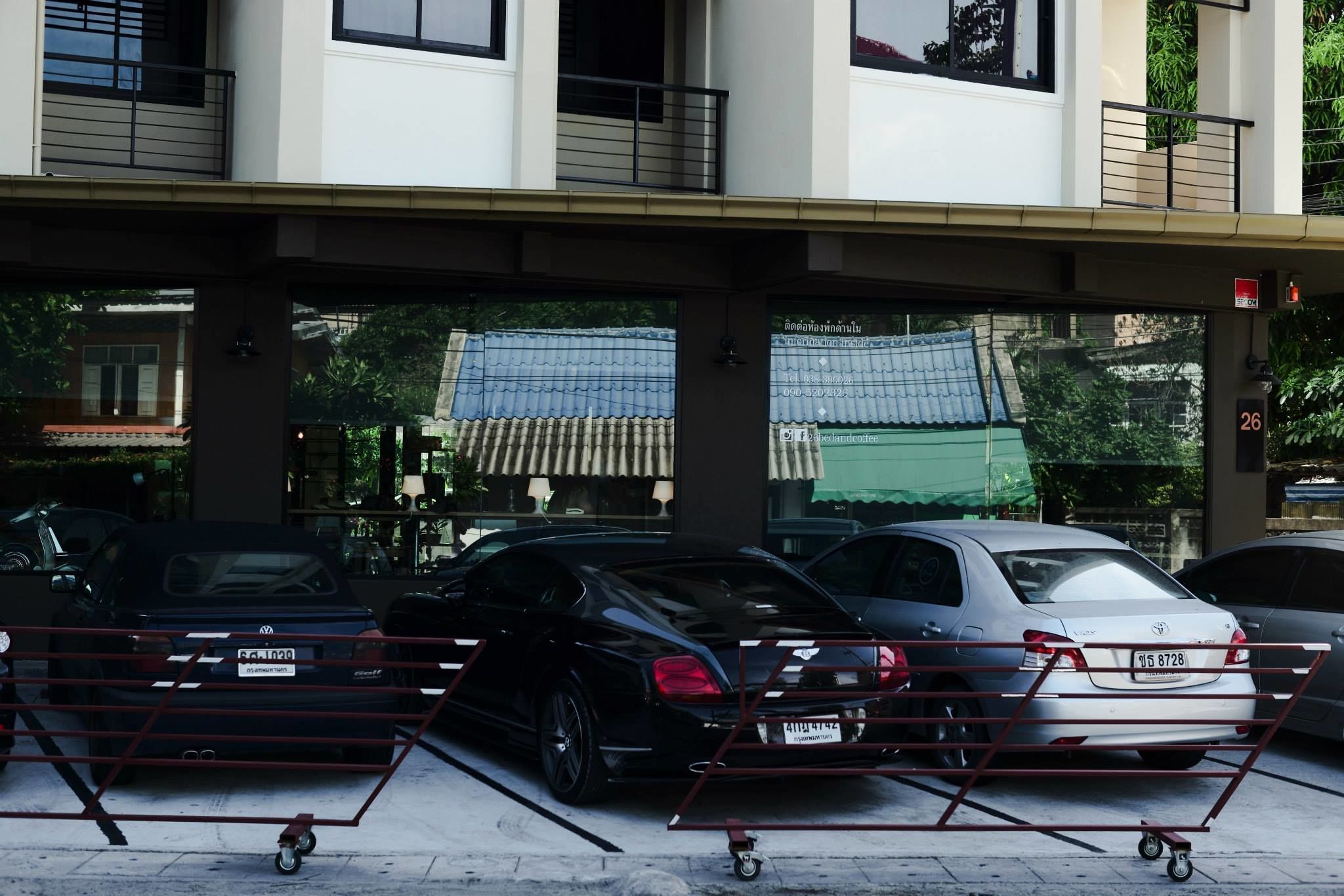 A parking area with cars and a red barrier.