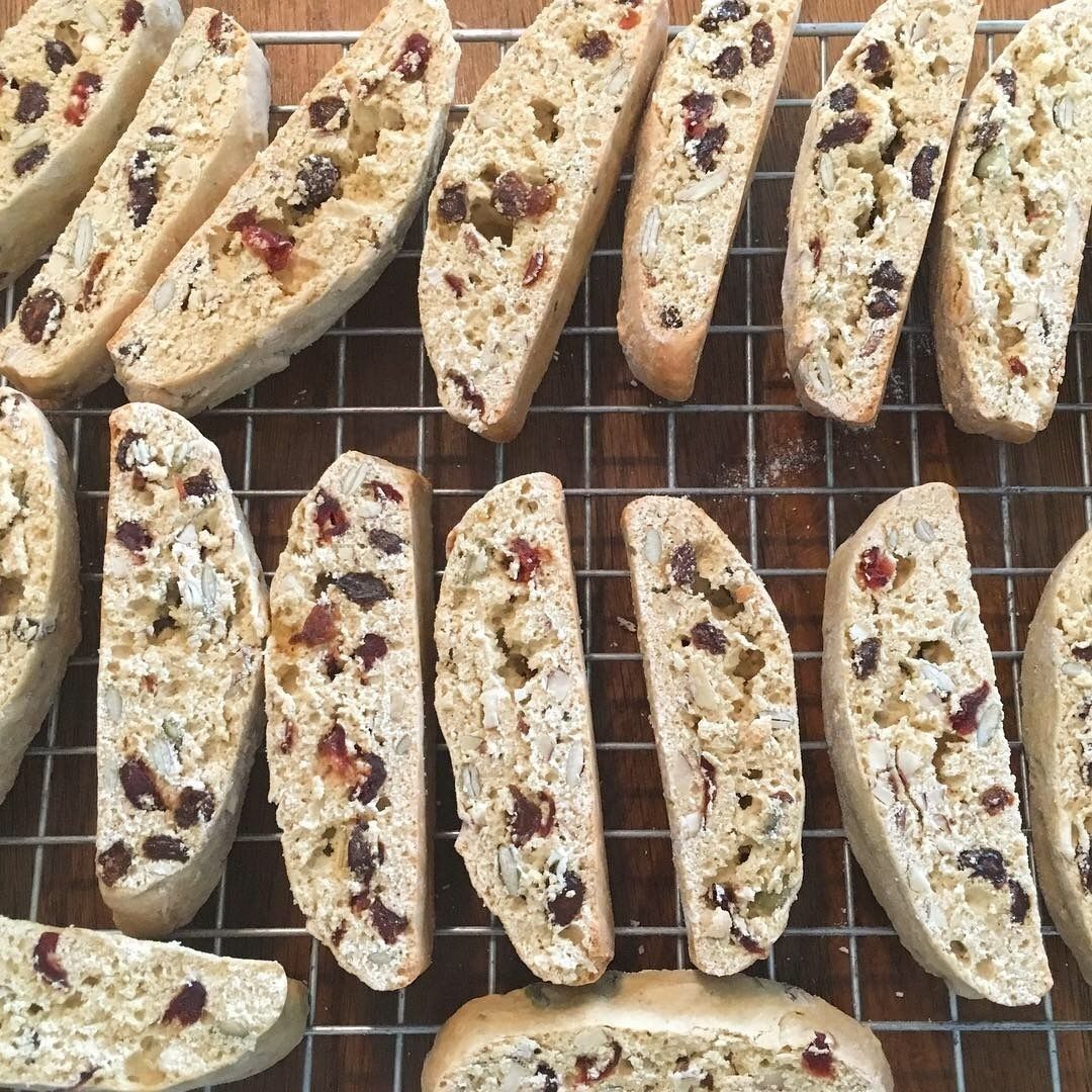 Rebanadas de pan con nueces y pasas visibles sobre una rejilla para enfriar.