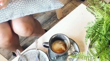 A table with a cup of coffee, a spoon, and a saucer.