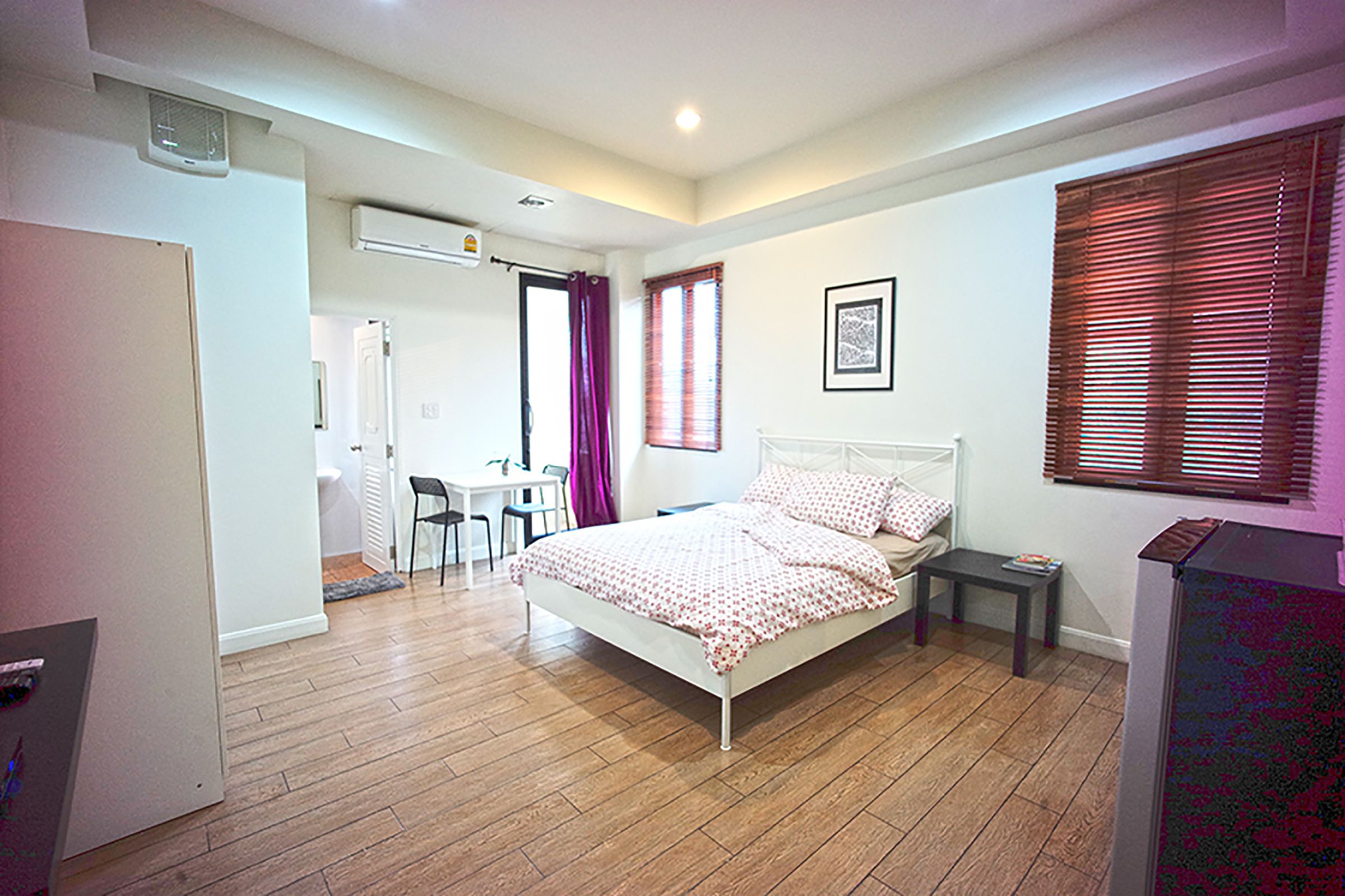 A bedroom with a bed, a desk, and a chair.