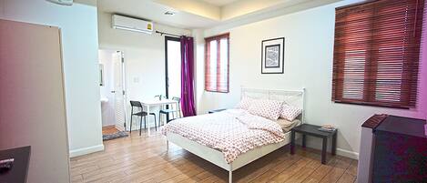A bedroom with a bed, a desk, and a chair.