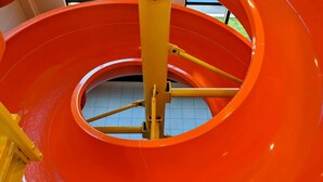 A large, circular, orange structure with a central support column and yellow beams. - Chateau Fredericton, Trademark Collection by Wyndham (Fredericton)