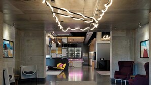 Un intérieur moderne comprenant un bar, des espaces pour s’asseoir et des œuvres d’art.
