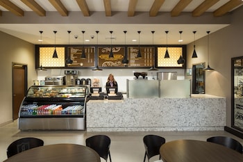 A modern hotel lobby with a curved ceiling, recessed lighting, and a statue in the center. at Parkwest Bicycle Casino