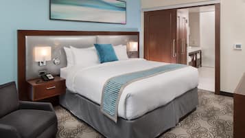 Habitación de hotel con una cama grande, una mesita de noche con teléfono, un escritorio y una silla.