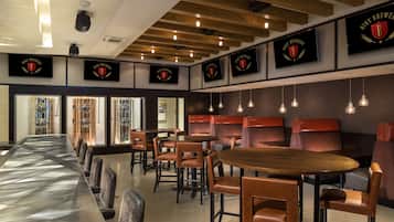 Un restaurante con largas mesas comunitarias y cabinas, vigas de madera en el techo y logotipos enmarcados en las paredes.