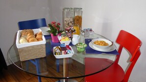 Una mesa de desayuno con diversos alimentos, como pan, bollería y salsas.