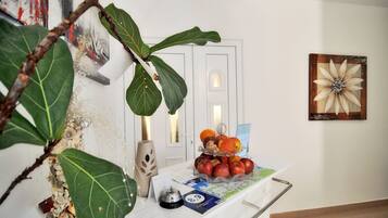 Un comptoir d’accueil agrémenté d’une plante, d’un vase et d’une présentation de fruits.