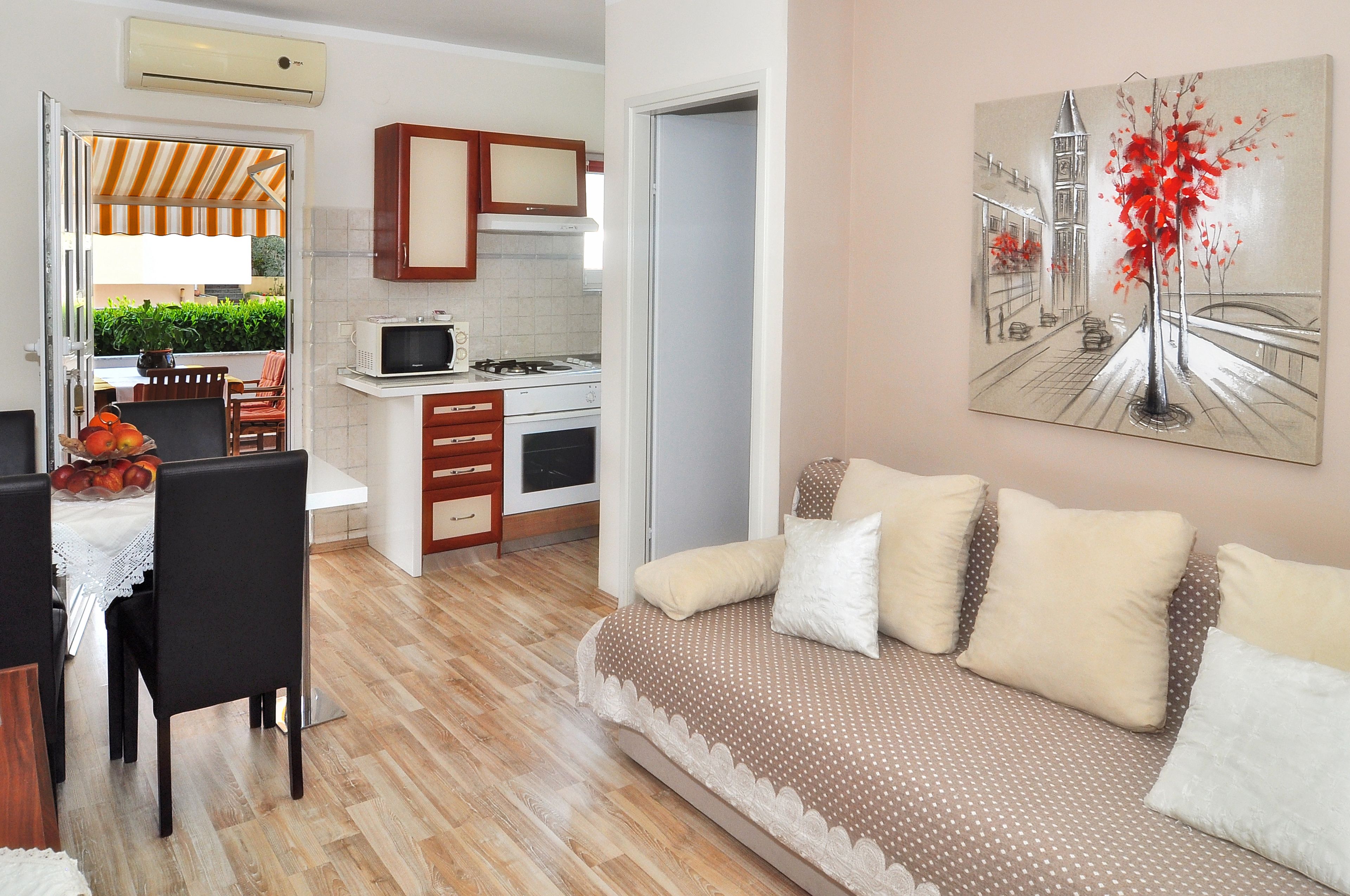 Un appartement moderne comprenant un coin repas, une kitchenette et un salon avec un canapé et un tableau.