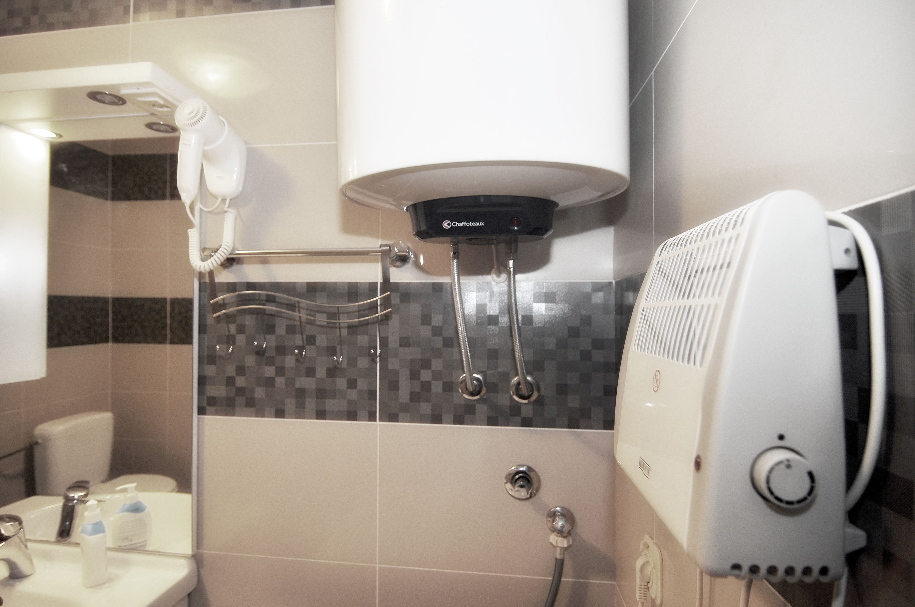 Une salle de bain avec douche, sèche-cheveux et porte-serviettes.