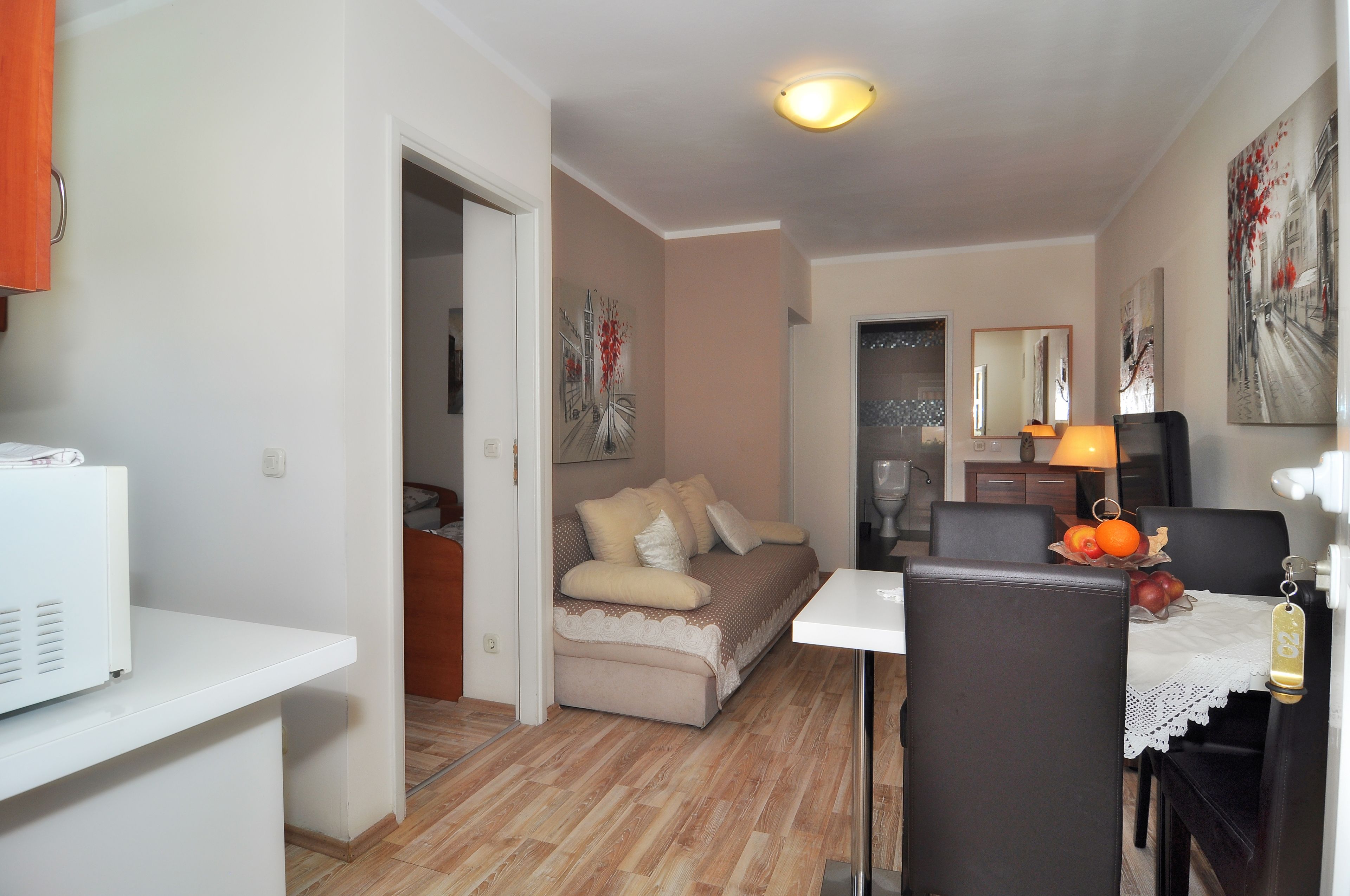 A compact living space with a kitchenette, a dining area, and a sofa.