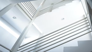 A modern interior with a geometric staircase design and skylights. - Opportunity León (León)