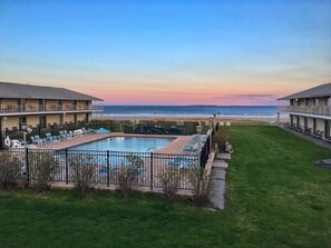 Um hotel com piscina e vista para o mar.