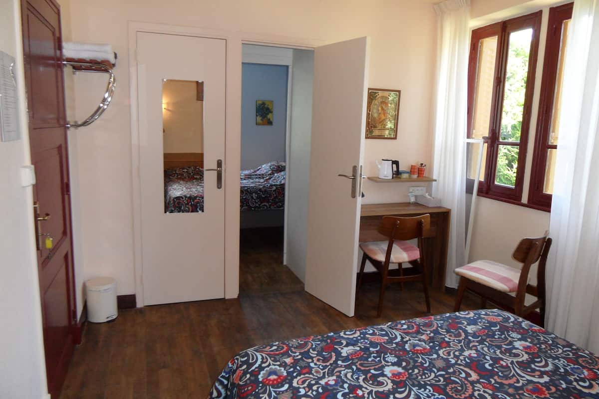 Habitación familiar | Espacio para trabajar con un portátil y tabla de planchar con plancha
