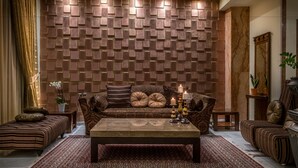 Ein modernes Wohnzimmer mit Wandverkleidung, einem Sofa, einem Couchtisch und einem Spiegel.