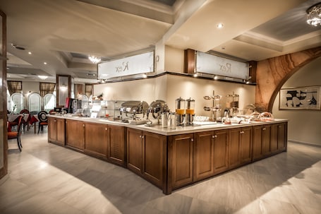 A spacious kitchen with wooden cabinets, a marble countertop, and various kitchen appliances.