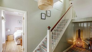 A staircase with a wooden handrail and a woven light fixture. - Hightae B&B (Lockerbie)