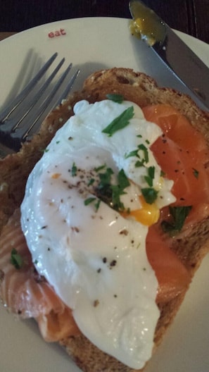 Enjoy a delicious breakfast with smoked salmon, poached egg, and fresh herbs on a stylish plate.