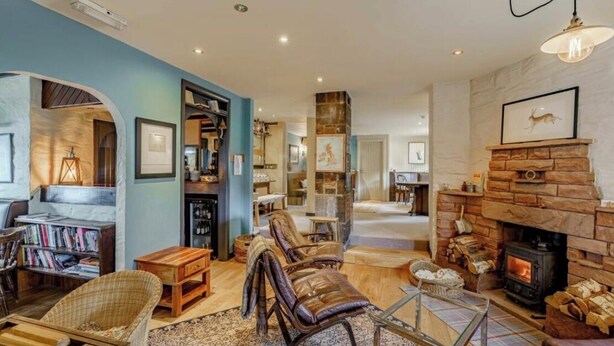 A cozy living room with a fireplace, bookshelves, and comfortable seating. - Hightae B&B (Lockerbie)