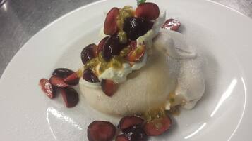 A dessert with fruit and whipped cream on a plate.