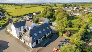A residential area with houses, a parking area, and green fields in the background. - Hightae B&B (Lockerbie)