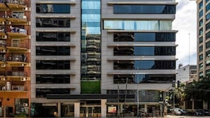 A modern multi-story building with a glass facade, a flat roof, and a ground-level entrance. - LM Hotel (Buenos Aires)