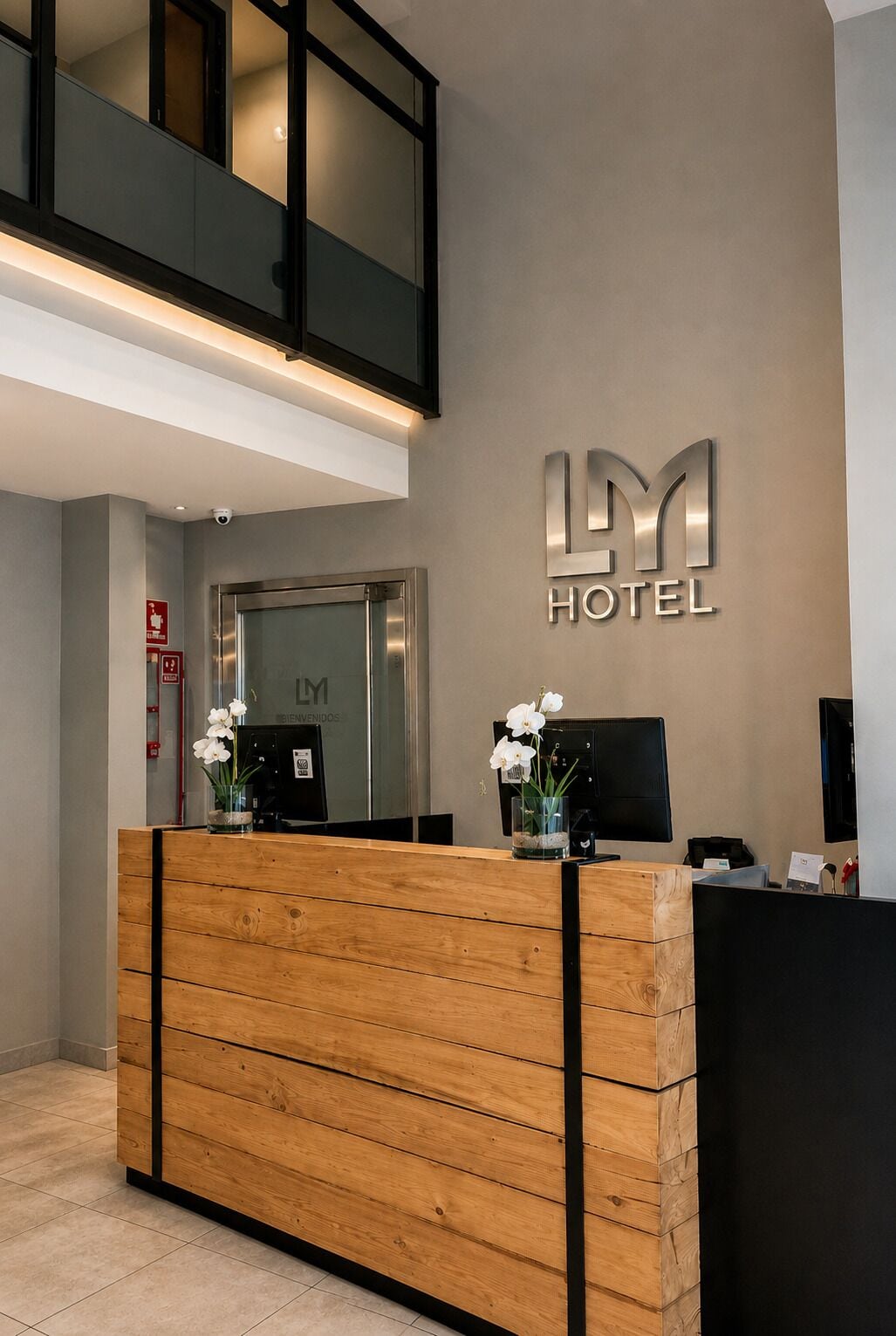 Uma receção de hotel com design moderno, uma tela digital e uma placa que diz 'LY HOTEL'.