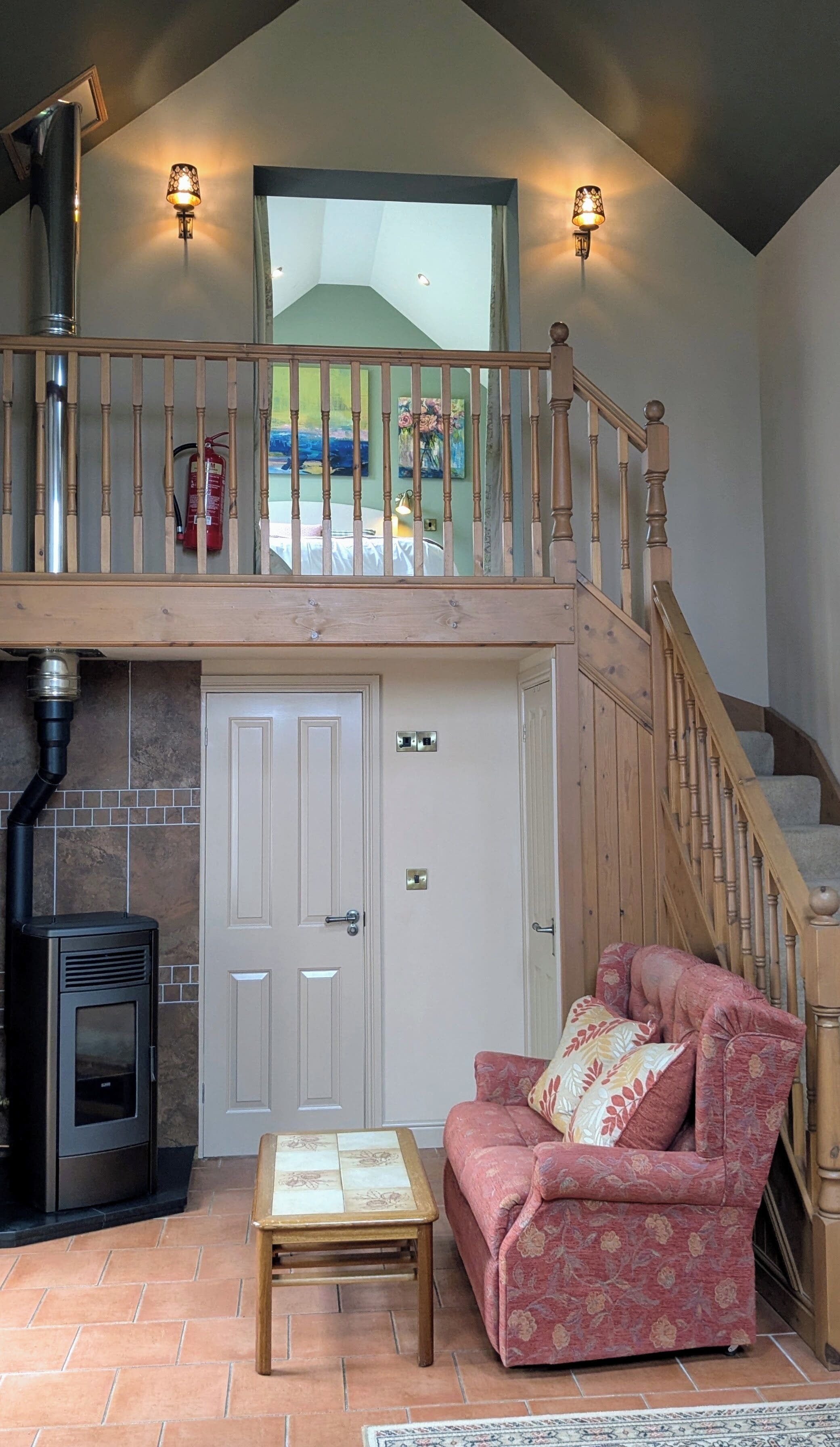 Un salon chaleureux avec une cheminée, un escalier en bois et une vue sur le jardin arrière.