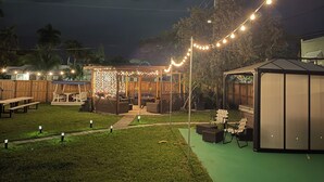 A patio area with string lights, outdoor furniture, and a covered seating area. - 4BR, 4BA House Beach, Entertainment, Nightlife (Hollywood)