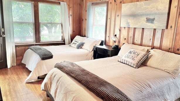 A wooden-paneled room with two beds, a desk, and a painting on the wall. - 4BR, 4BA House Beach, Entertainment, Nightlife (Hollywood)