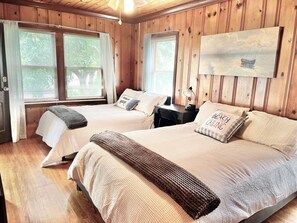 A wooden-paneled room with two beds, a desk, and a painting on the wall. - 4BR, 4BA House Beach, Entertainment, Nightlife (Hollywood)